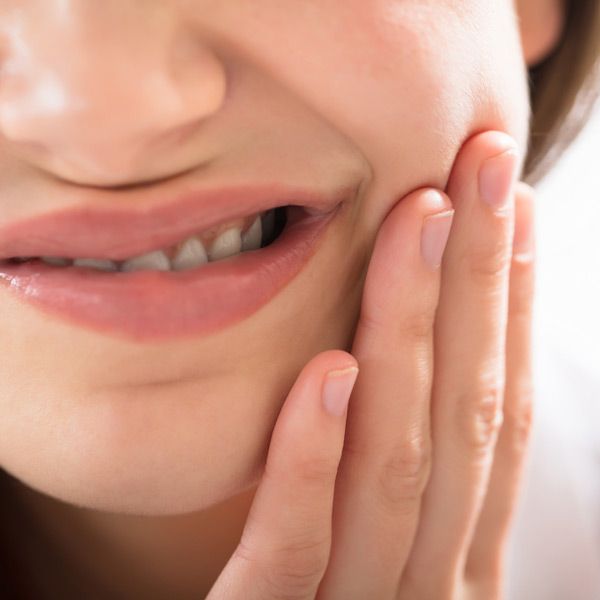 Woman holding hand to jaw